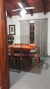 mesa de comedor con 2 sillas y mesa de madera en Casa Santa Elena en Malargüe