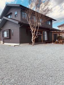 una casa con un árbol y una entrada de grava en 道龍house, en Azagawa