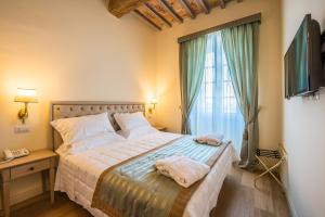- une chambre avec un lit et des serviettes dans l'établissement Relais Paradiso Resort & Spa, à Gualdo Cattaneo