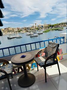 a balcony with a table and chairs and a view of a harbor at La Terrace in Aswan