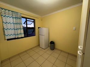 een keuken met een koelkast en een raam bij Ramblers Self-Catering Hostel (No Aircon/No TV/No Pool) in Windhoek