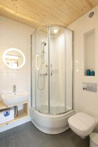 a bathroom with a shower and a toilet and a sink at Dom Wakacyjny Solano in Ustka +24 photos