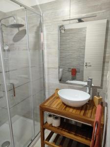 een badkamer met een witte wastafel en een douche bij Holiday house Chiara in Giardini Naxos