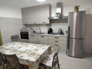 a kitchen with a table and a stainless steel refrigerator at Holiday house Chiara in Giardini Naxos