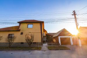 a house with the sun setting behind it at Casa de pe colt in Alba Iulia