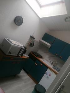 een zolderkamer met een bureau met een computer en een klok bij Studio Sulniac Golfe du morbihan in Sulniac