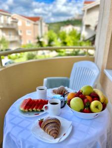 a table with fruit and coffee on a balcony at Sunshine house in Herceg-Novi