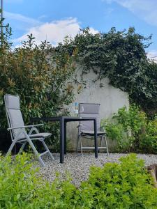 2 sillas y una mesa en un jardín en Ferienwohnung Panoramablick, en Bad Mergentheim