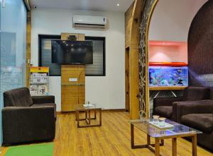 a living room with a couch and a fish tank at Grandeur By Avion Palace Near T2 International Airport in Mumbai