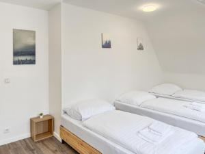 twee bedden in een kamer met witte muren bij T&K Apartments - Krefeld Zentrum - 1 and 2 room Apartment 20min to Fair DUS in Krefeld