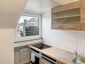 een kleine keuken met een wastafel en een raam bij T&K Apartments - Krefeld Zentrum - 1 and 2 room Apartment 20min to Fair DUS in Krefeld