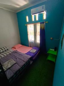 a small bedroom with a bed and a window at Backpackers Homestay in Labuan Bajo