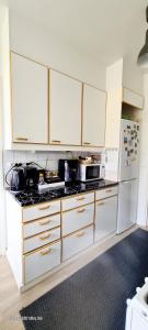 a kitchen with white cabinets and a stove top oven at Private room only in apartment at Herttoniemi in Helsinki