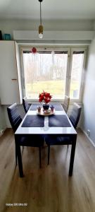 a dining room table with chairs and a large window at Private room only in apartment at Herttoniemi in Helsinki