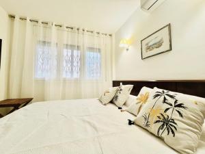 Un dormitorio con una gran cama blanca con plantas. en Ancora Salou primera línea, en Salou