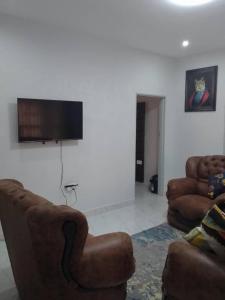 a living room with two couches and a flat screen tv at Luxury 3 Bedroom Self Catering Apartment- Masvingo in Nyanda