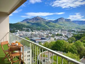 d'une table et d'une chaise sur un balcon avec vue sur les montagnes. dans l'établissement Le Golden View - Vue Imprenable & Parking Gratuit, à Chambéry