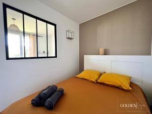 - une chambre avec un lit doté d'oreillers jaunes et d'une fenêtre dans l'établissement Le Golden View - Vue Imprenable & Parking Gratuit, à Chambéry