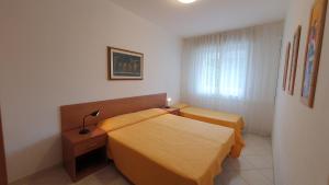 een hotelkamer met 2 bedden en een raam bij Residence Luna in Lignano Sabbiadoro