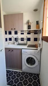 eine Küche mit einer Waschmaschine und einem Waschbecken in der Unterkunft Le Sel du Bonheur in Gruissan