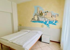 Schlafzimmer mit einem Bett mit Wandgemälde in der Unterkunft Hotel Ideal in Malcesine