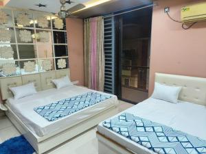 a bedroom with two beds and a window at Nataraj Homestays in Ujjain