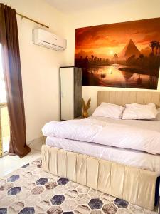 um quarto com duas camas e um quadro na parede em 4 Pyramids inn no Cairo