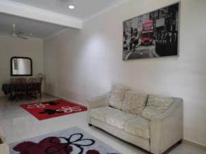 un salon avec un canapé et un tableau au mur dans l'établissement Homestay Al amin 2, à Kampong Sura Tengah