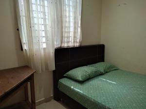 une petite chambre avec un lit et une fenêtre dans l'établissement Homestay Al amin 2, à Kampong Sura Tengah