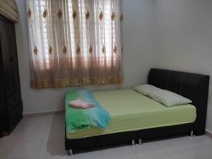 un lit assis dans une pièce avec une fenêtre dans l'établissement Homestay Al amin 2, à Kampong Sura Tengah