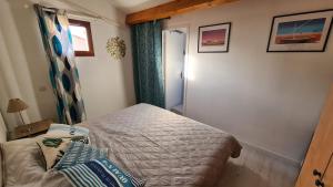 ein kleines Schlafzimmer mit einem Bett und einem Fenster in der Unterkunft Le Sel du Bonheur in Gruissan