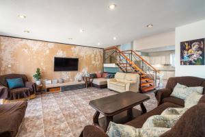 a living room with couches and a flat screen tv at Artzy Villa in Rhodes Town