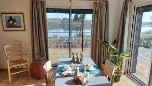 a dining room with a table and a large window at maison caroline bairon in Le Chesne +12 photos