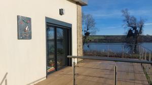 a building with a balcony with a view of the water at maison caroline bairon in Le Chesne