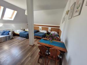 a living room with a table and two beds at Oberża Pod Kudłatym Aniołem in Cisna +46 photos