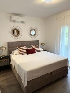 マカルスカにあるHoliday Home Meriのベッドルーム1室(大型ベッド1台、壁に鏡2つ付)