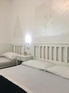 サンタ・ドメーニカにあるB&B A casa di Picciのベッド2台とテーブルのある白い寝室