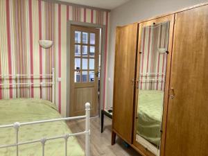 Schlafzimmer mit einem Bett und einem Holzschrank in der Unterkunft Charming 2-room flat near Paris in Nogent-sur-Marne