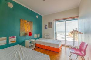 sypialnia z 2 łóżkami, oknem i krzesłem w obiekcie Stunning View of São Lourenço Beach w mieście Santo Isidoro
