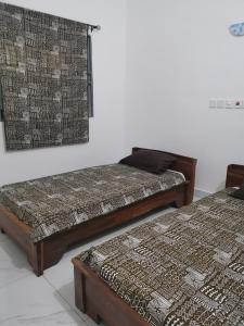 two beds sitting next to each other in a room at Le Havre Béninois in Cotonou