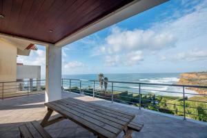 balkon z drewnianą ławką i widokiem na ocean w obiekcie Stunning View of São Lourenço Beach w mieście Santo Isidoro