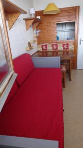 a living room with a red couch and a table at BORSAT 4 in Tignes