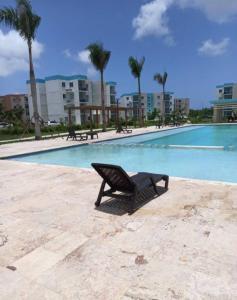 a black chair sitting next to a swimming pool at Vip Village Service in Punta Cana