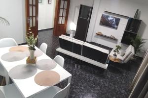 - un salon avec deux tables et un piano dans l'établissement CASA MARY, Céntrico y amplio piso cerca del mar, en Candelaria, à Candelaria