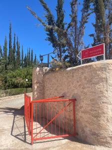 a red gate on top of a stone wall at RIAD YANITRI in Essaouira