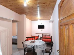 a dining room with a table and chairs and a tv at Departamento Payún Matrú in Malargüe
