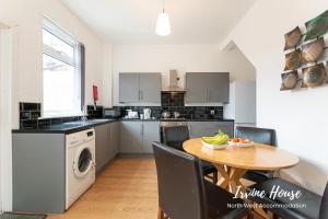 a kitchen with a table and a kitchen with a washing machine at Irvine Contractor Accommodation in Leigh