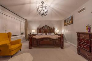 um quarto com uma cama grande e uma cadeira amarela em Huge House em Ottawa