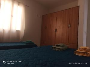 een slaapkamer met twee bedden en een ladekast bij Hospedaje Los Macaes 2 in Comodoro Rivadavia