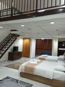 a large bedroom with two beds and a staircase at Maytower Apartment in Kuala Lumpur